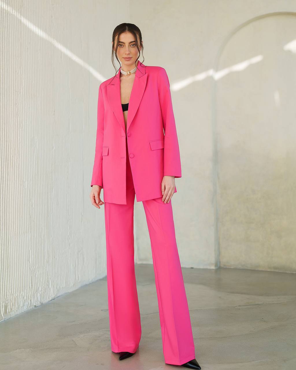 Woman wearing a bright pink suit in an indoor setting