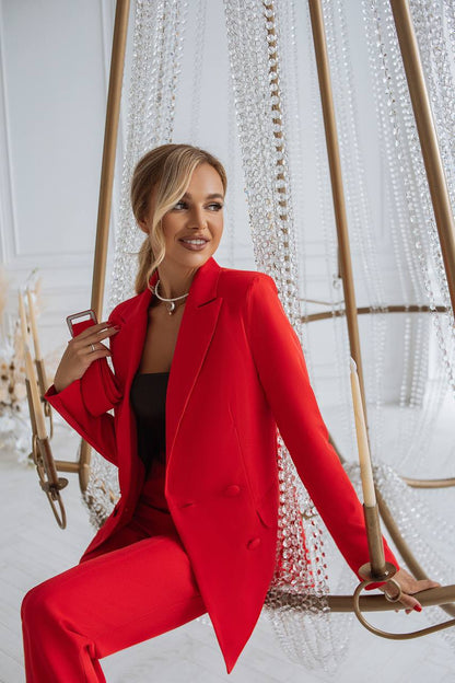 Woman in a red outfit sitting on a decorative swing indoors.