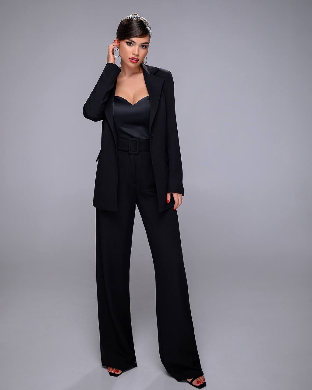 Woman wearing a black suit on a gray background