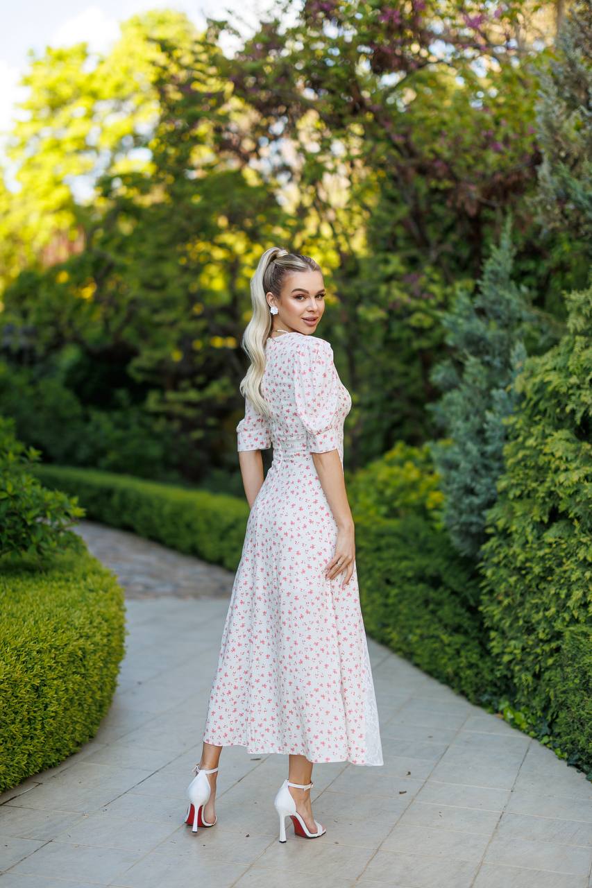 Woman in a floral dress standing in a garden