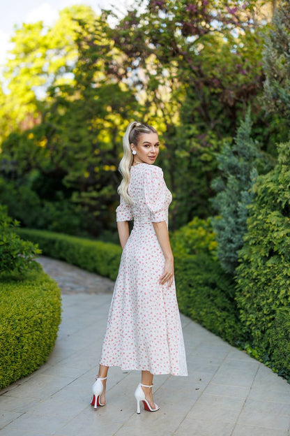 Woman in a floral dress standing in a garden