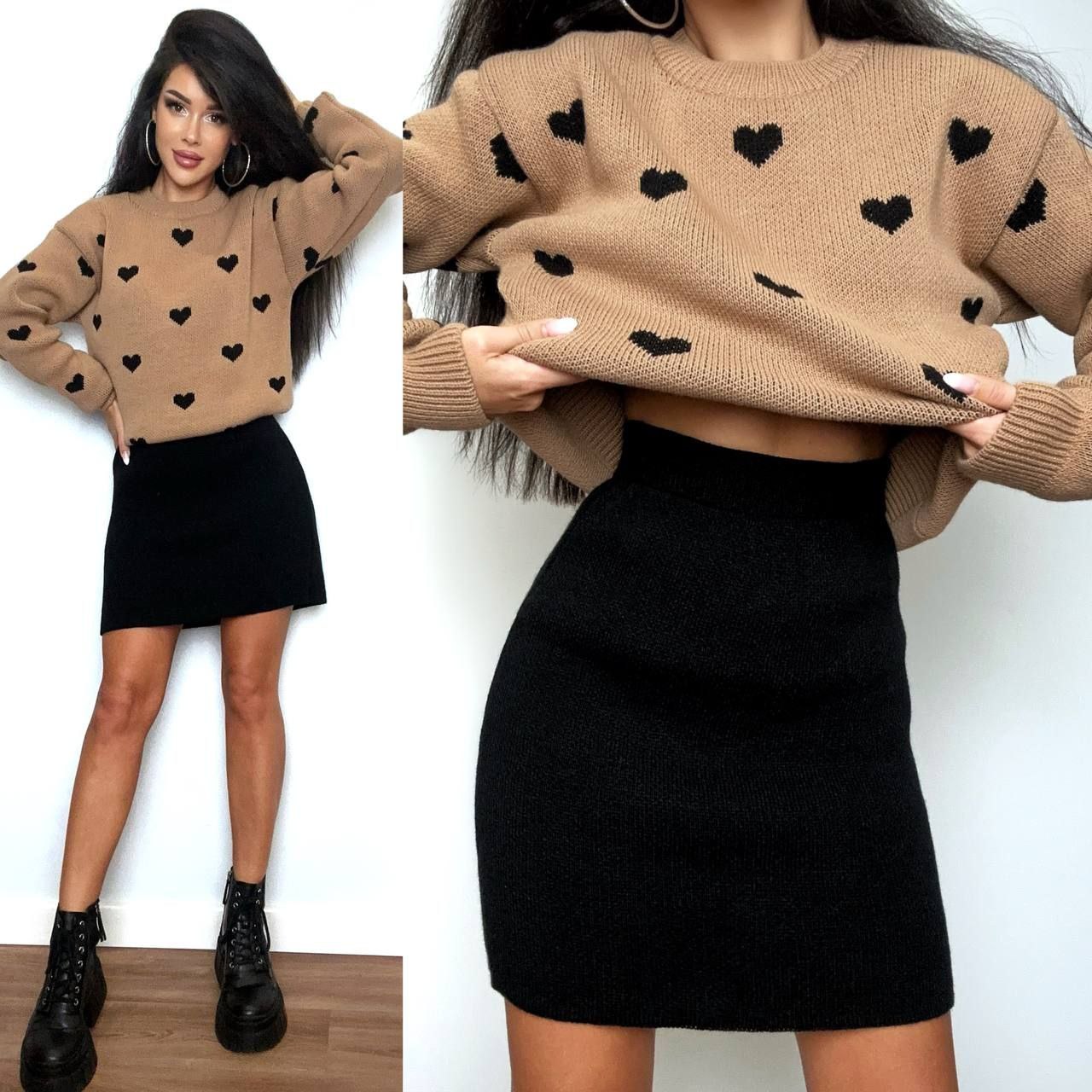Woman wearing a beige sweater with black heart patterns and a black skirt.