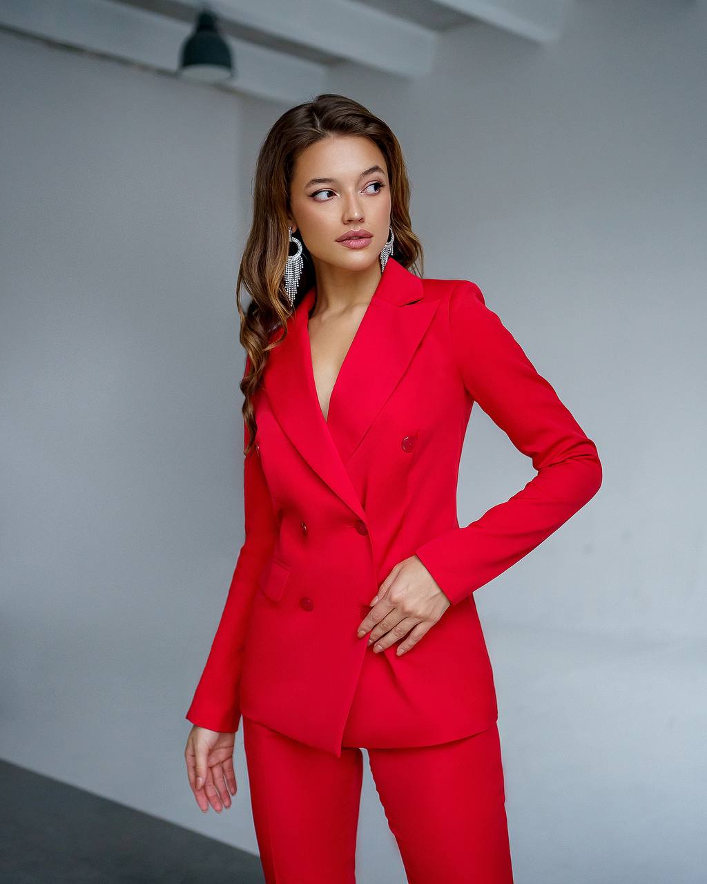 Woman wearing a red suit against a plain background