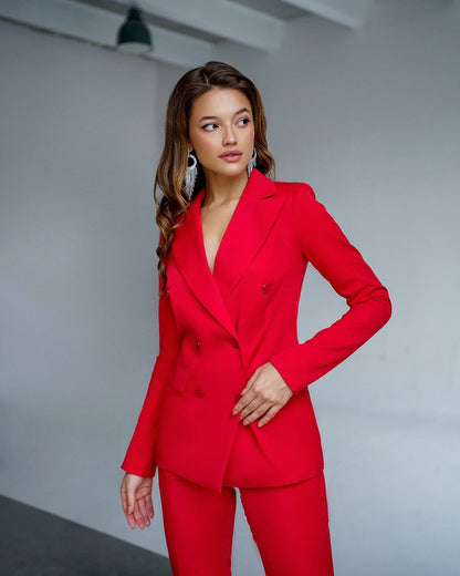 Woman wearing a red suit against a plain background