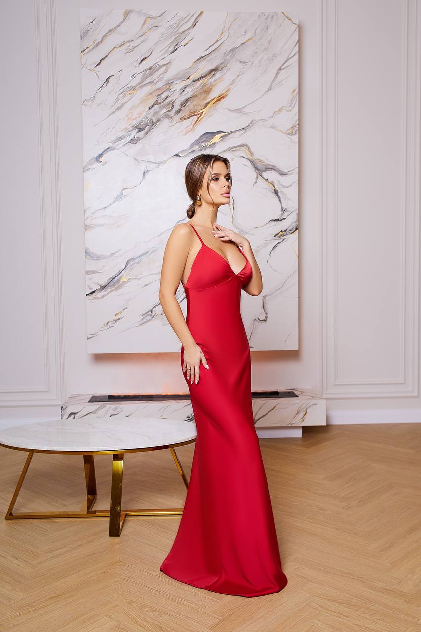 Woman in a red dress standing in a stylish room with marble wall art.