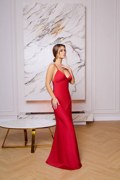 Woman in a red dress standing in a stylish room with marble wall art.