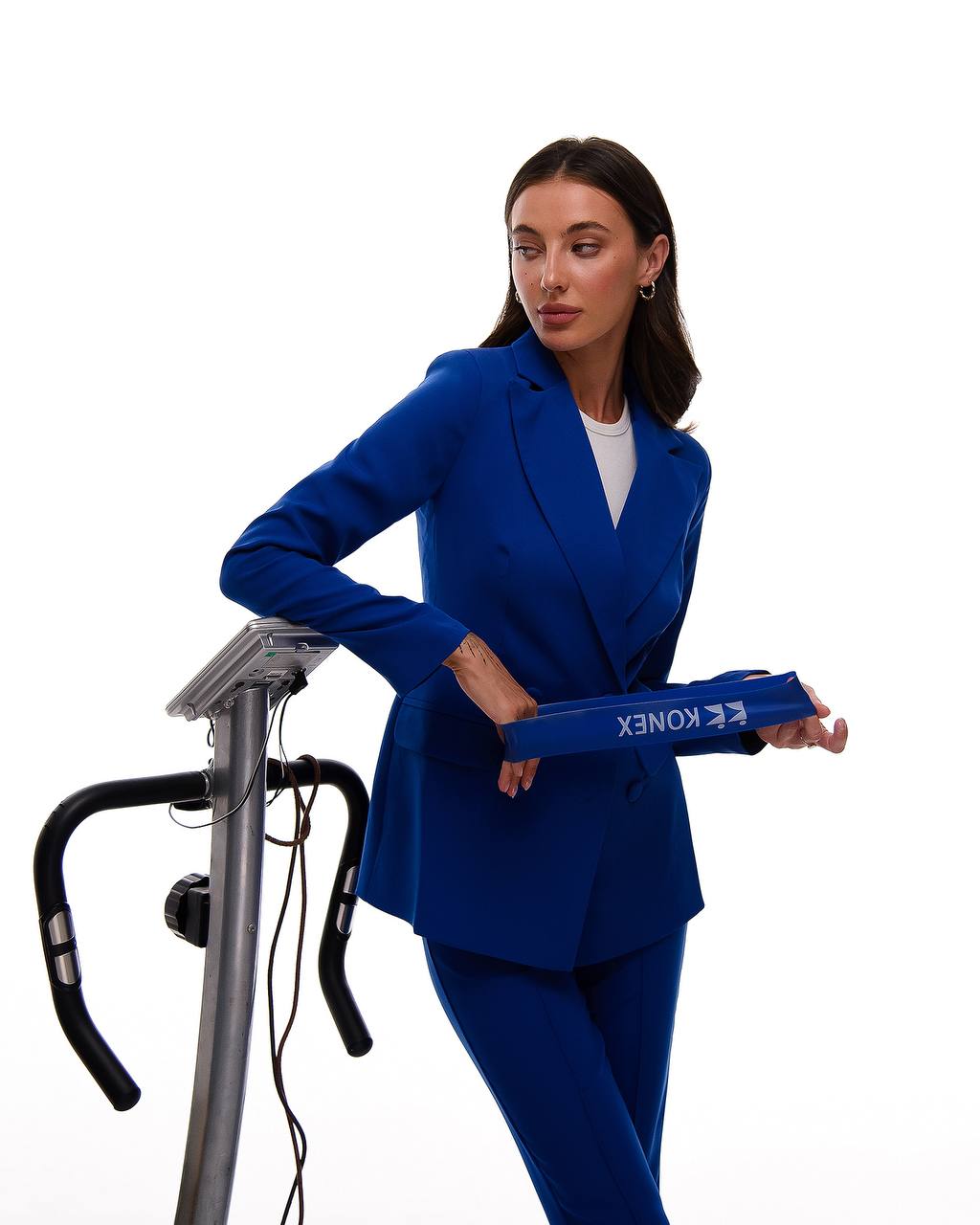 Woman in a blue suit holding a KoneX product on a white background