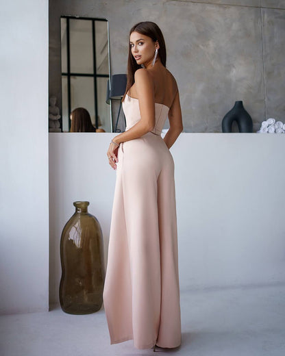 Woman in a pink dress standing in a modern interior setting with vases.