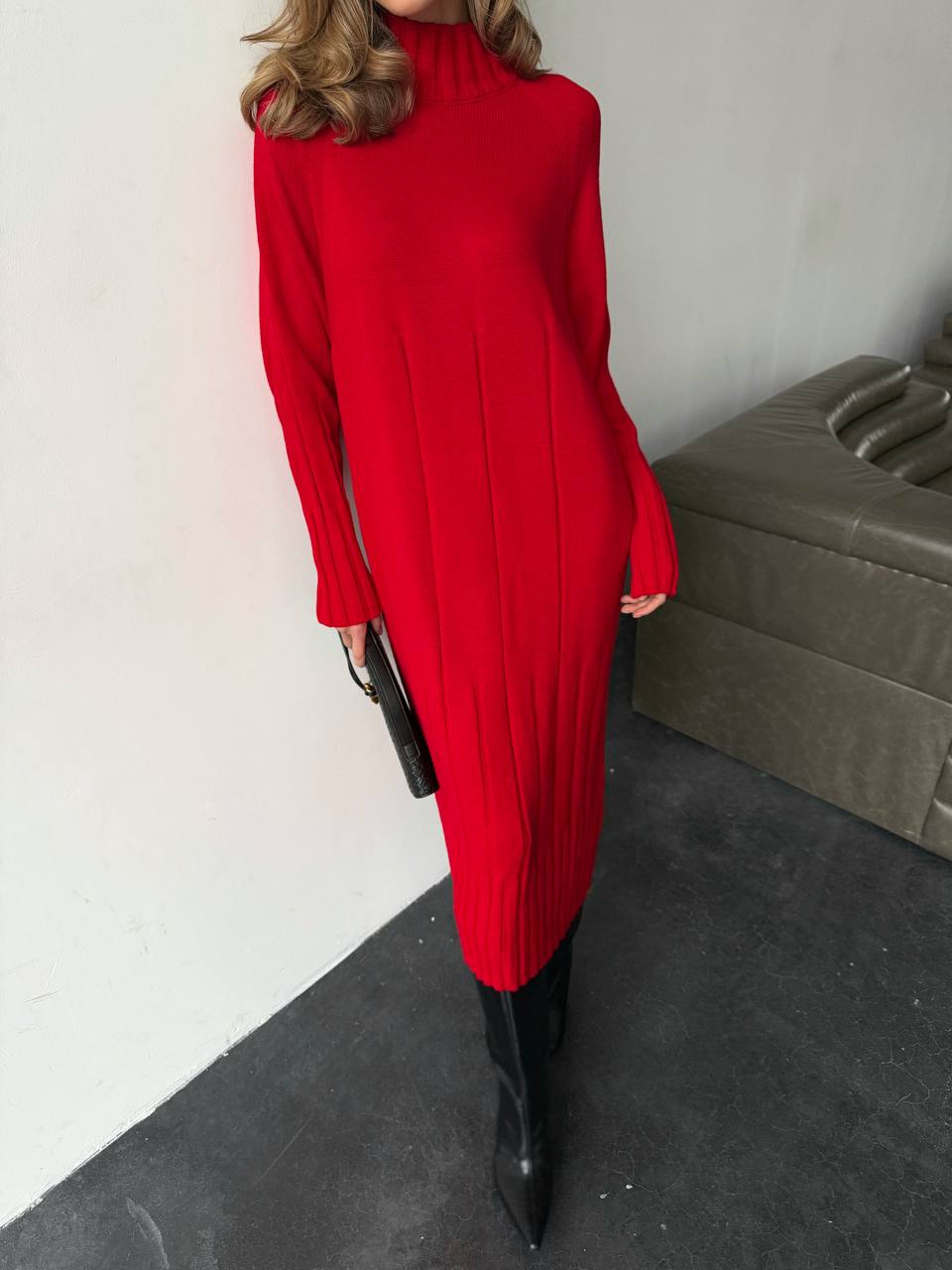 Person wearing a red dress with long sleeves in an indoor setting.