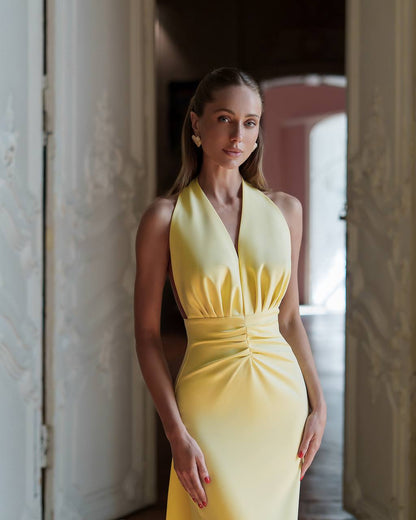 Woman wearing a yellow dress standing in an indoor setting