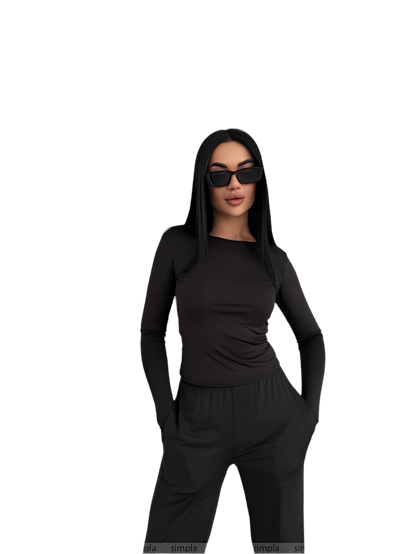 Woman wearing a black outfit with sunglasses on a white background