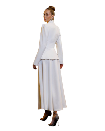 Woman wearing a white outfit with a high collar and long skirt on a white background