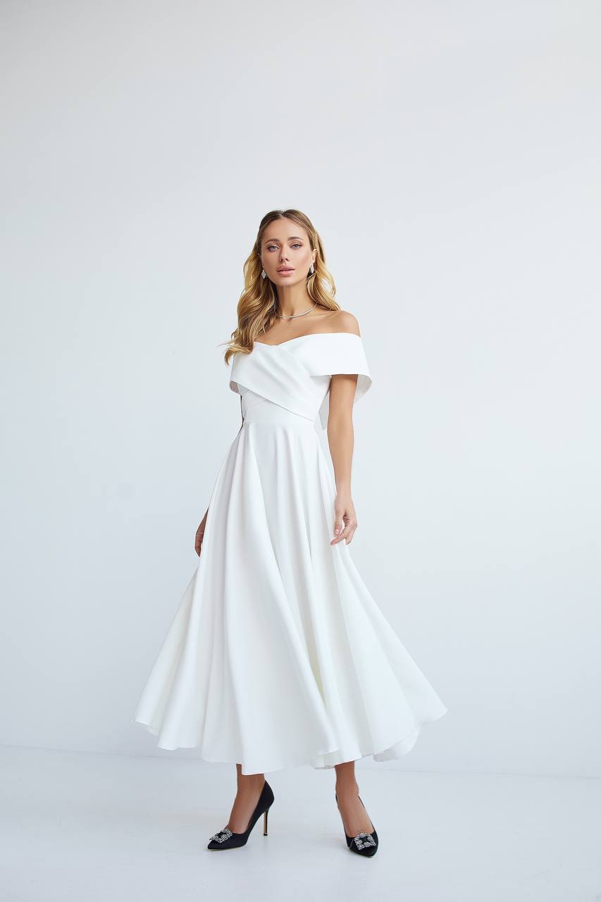 Woman wearing a white off-shoulder dress on a light gray background