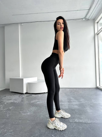 Woman wearing black athletic wear in a minimalistic room