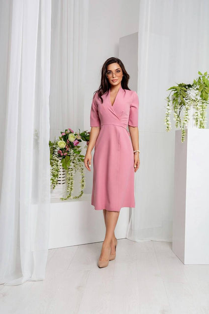 Woman in a pink dress standing in a minimalistic room with white curtains and plants.