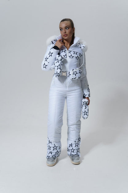 Person wearing a white snowsuit with star patterns on a plain background