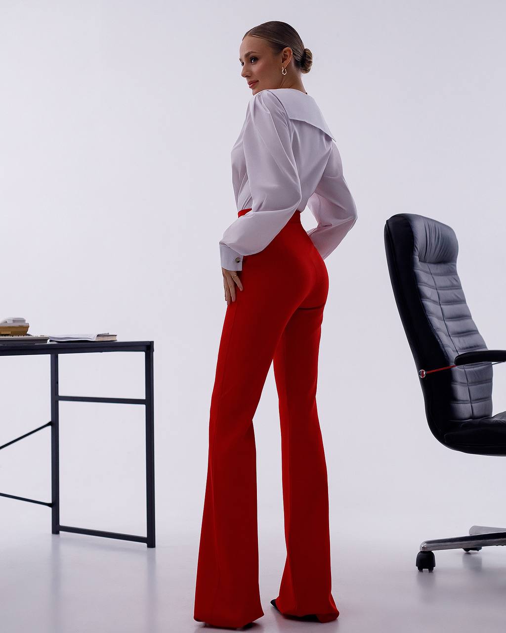 Person wearing a white shirt and red pants in an office setting