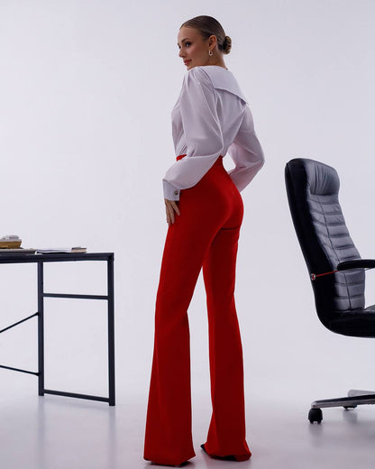 Person wearing a white shirt and red pants in an office setting