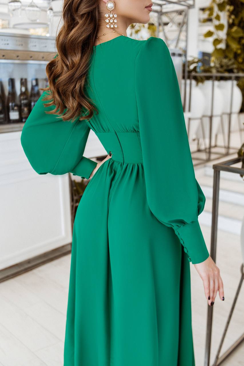 Green dress with long sleeves worn by a person indoors.