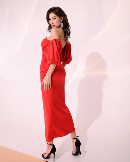Woman wearing a red off-shoulder dress with a plain background