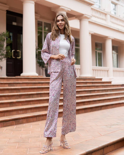 Woman in a floral outfit standing in front of a building with columns.