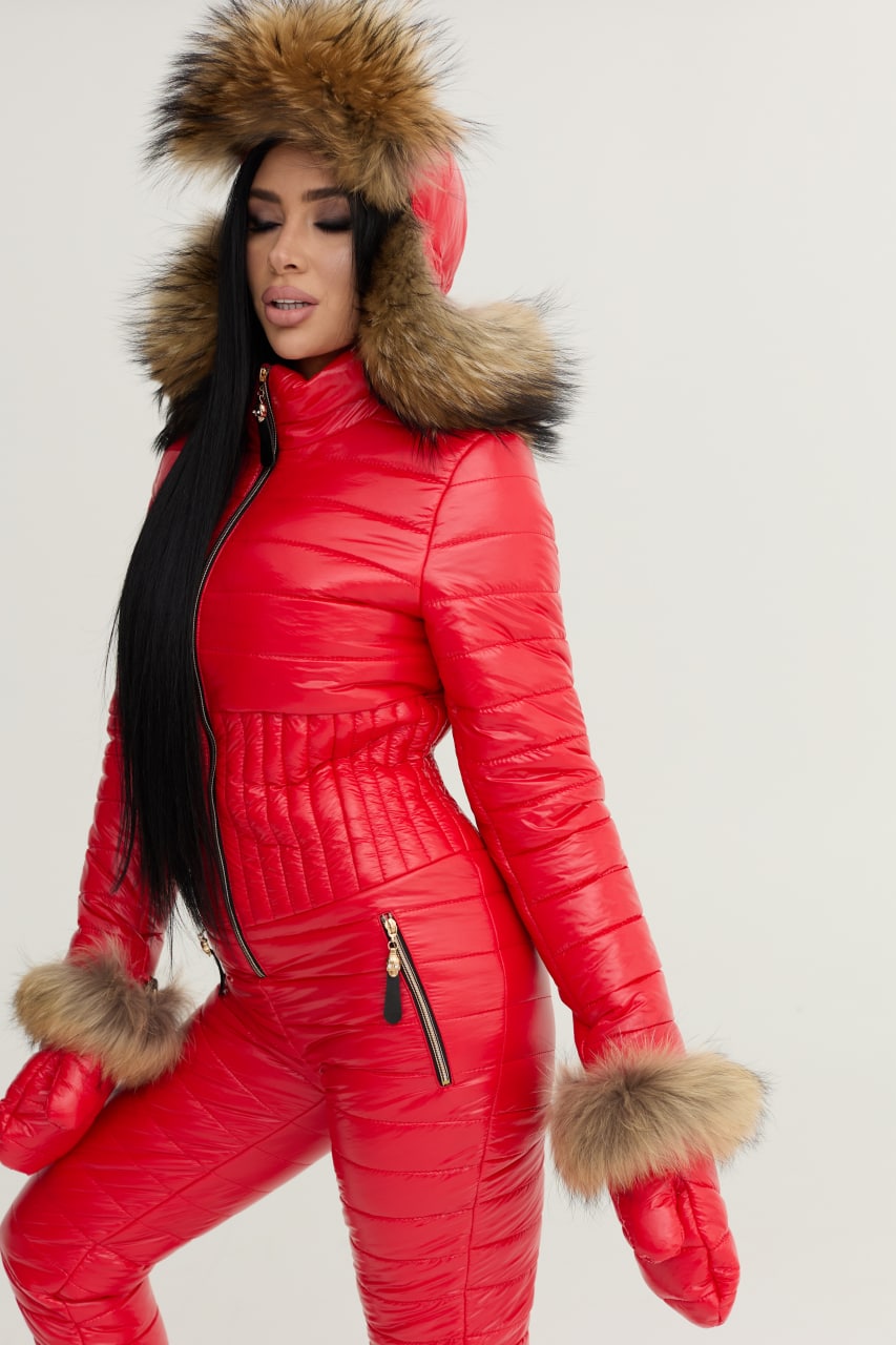 Person wearing a red puffer suit with fur trim on a white background