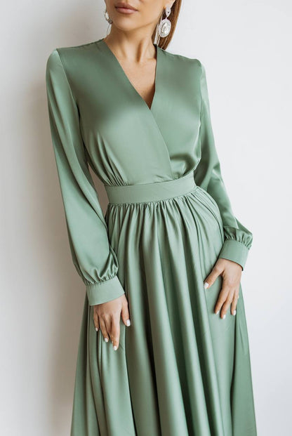 Green dress with long sleeves on a plain background