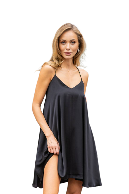 Woman wearing a black slip dress on a white background