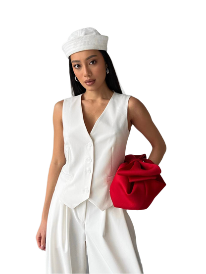 Woman in a white outfit with a red clutch on a white background