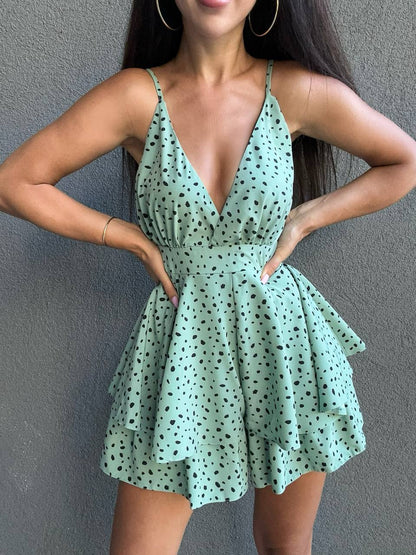Woman wearing a green polka dot dress against a gray background