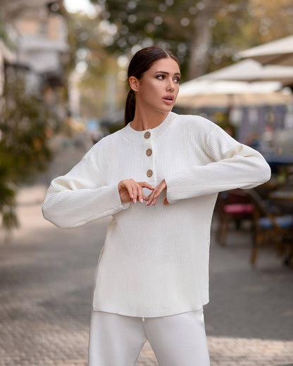 Woman wearing a white sweater with button details outdoors