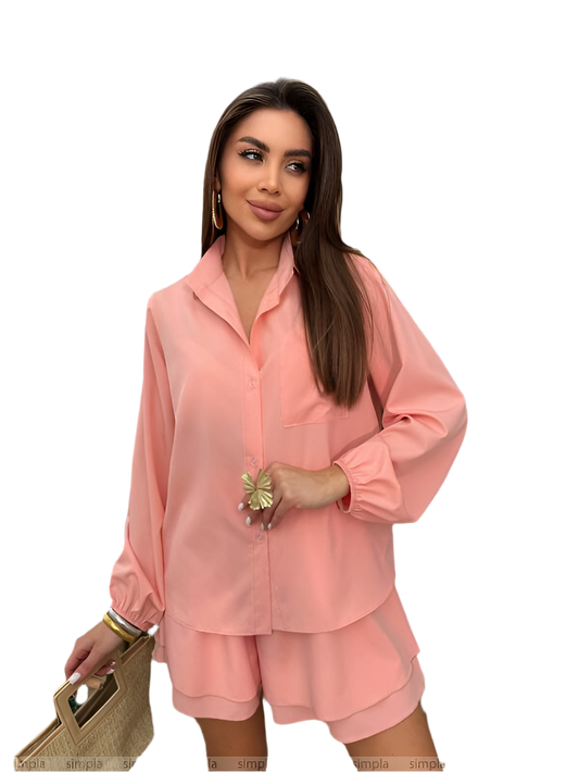 Woman wearing a pink outfit holding a straw bag on a white background