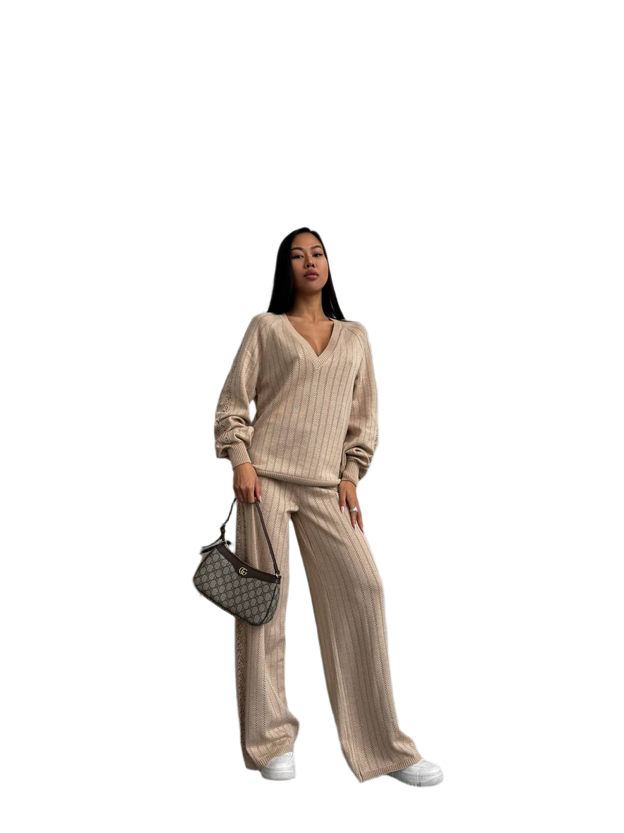 Woman wearing a beige striped outfit with a handbag on a white background