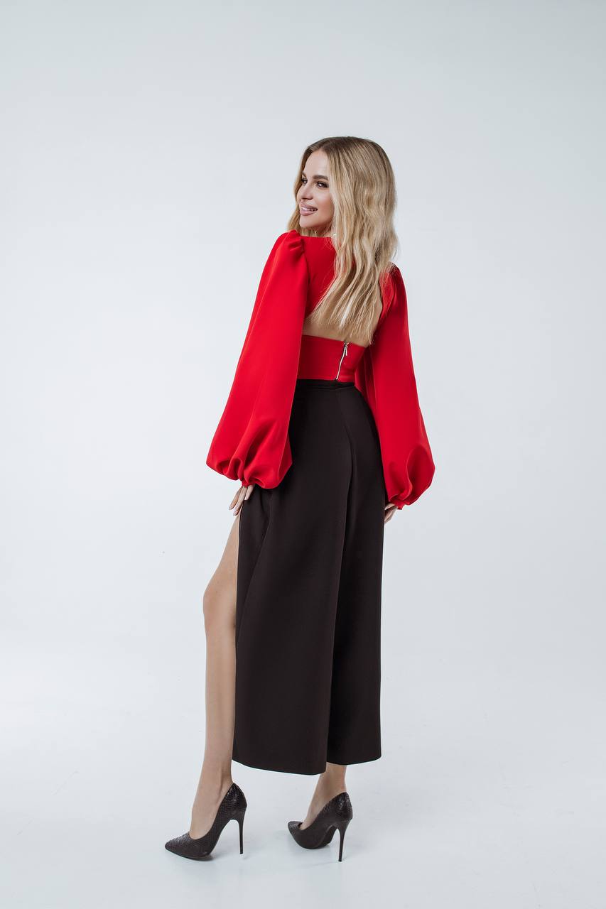 Woman wearing a red jacket and black pants on a white background