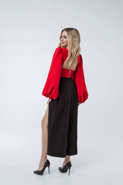Woman wearing a red jacket and black pants on a white background