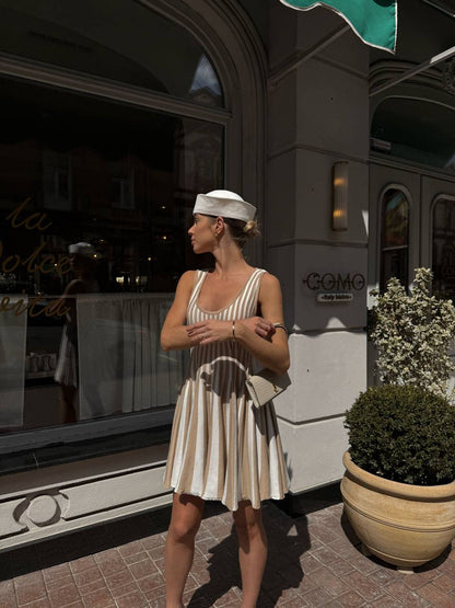 Woman in a striped dress standing outside a building with a sign that reads 'Congo'.