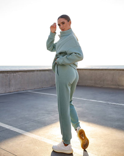 Person wearing a light blue tracksuit standing on a rooftop.
