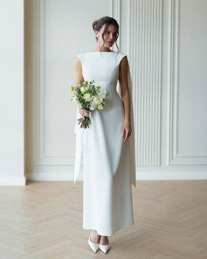 Woman in a white dress holding a bouquet of flowers in a minimalistic setting