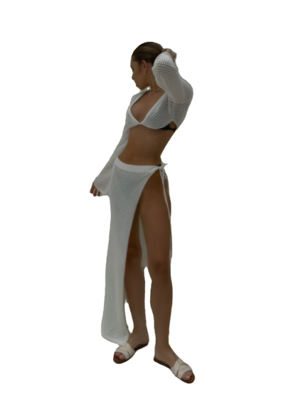 Woman wearing a white outfit with a high slit on a white background