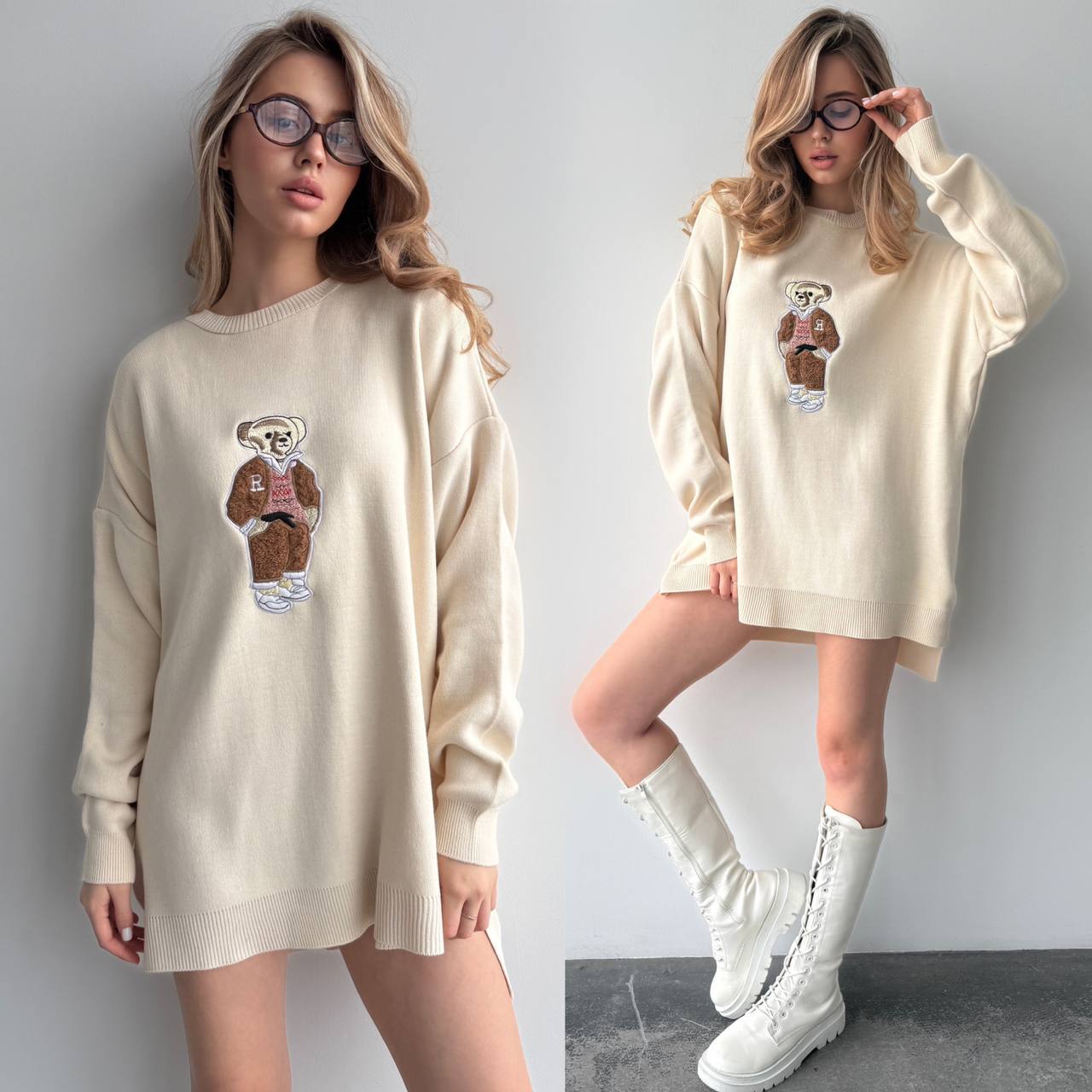 Woman wearing a cream-colored sweater with a bear graphic, paired with white boots against a plain background.