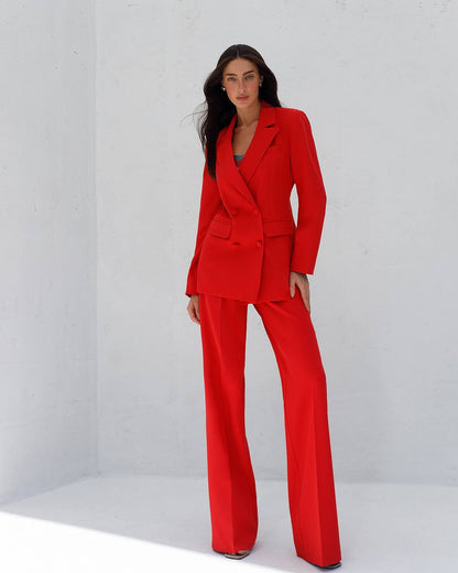 Woman wearing a red suit against a white background