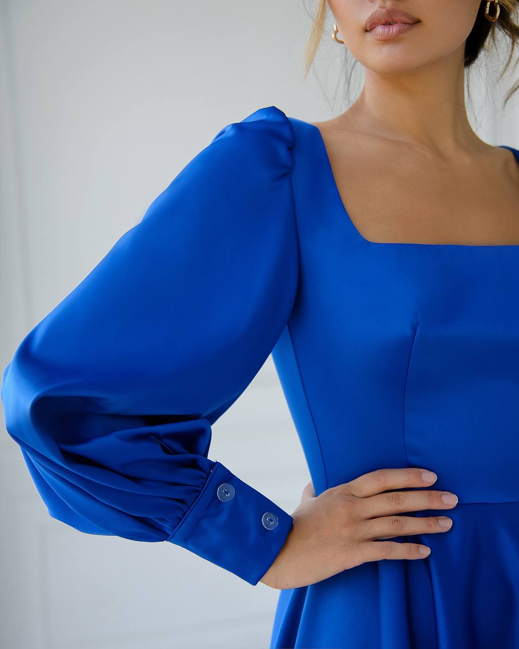Blue dress with puffed sleeves worn by a person against a plain background