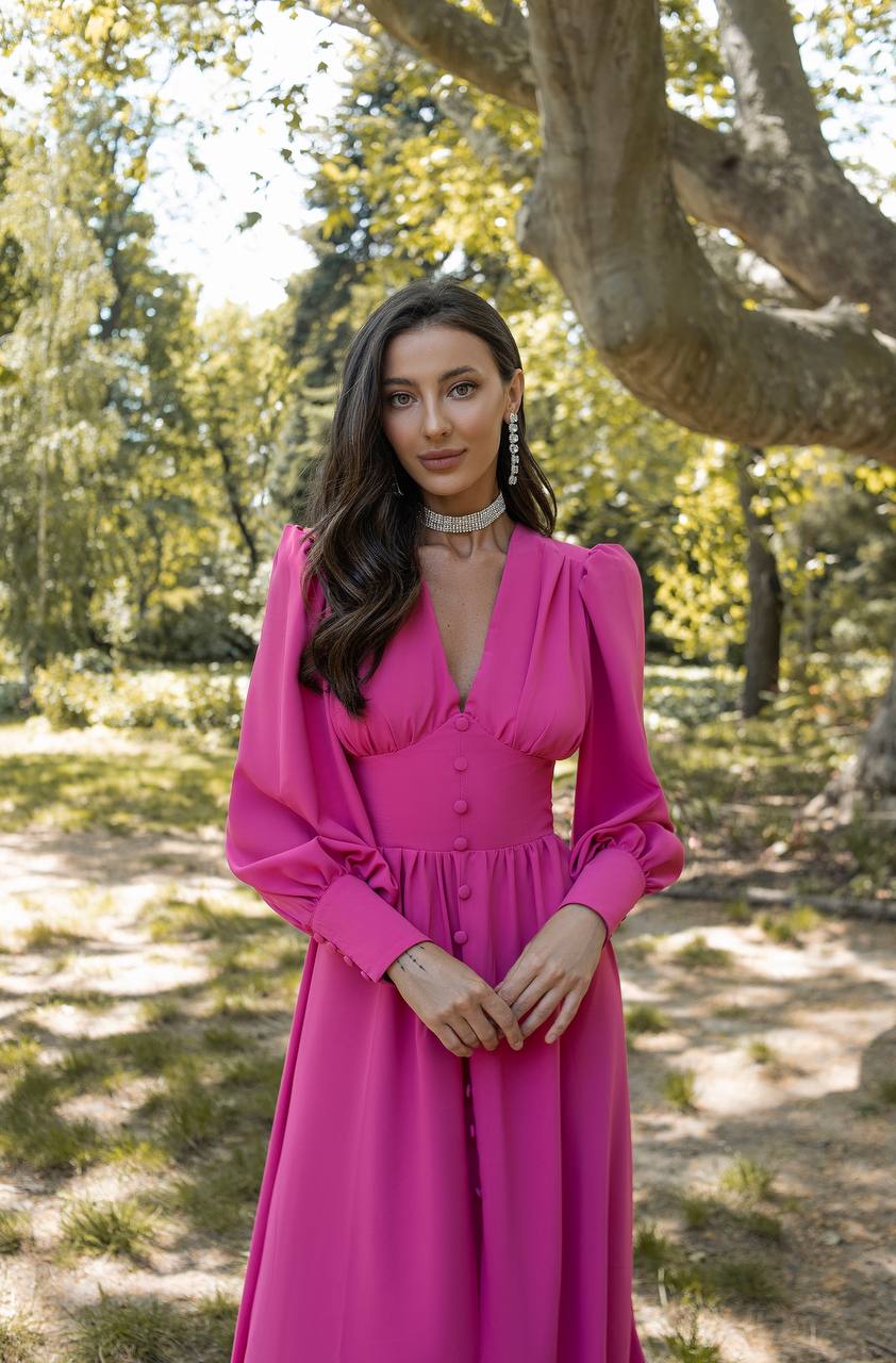 Woman in a pink dress standing in a forested area