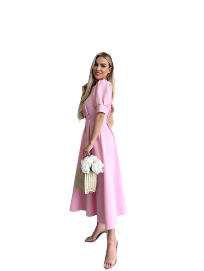 Woman in a pink dress holding flowers and a bag on a white background