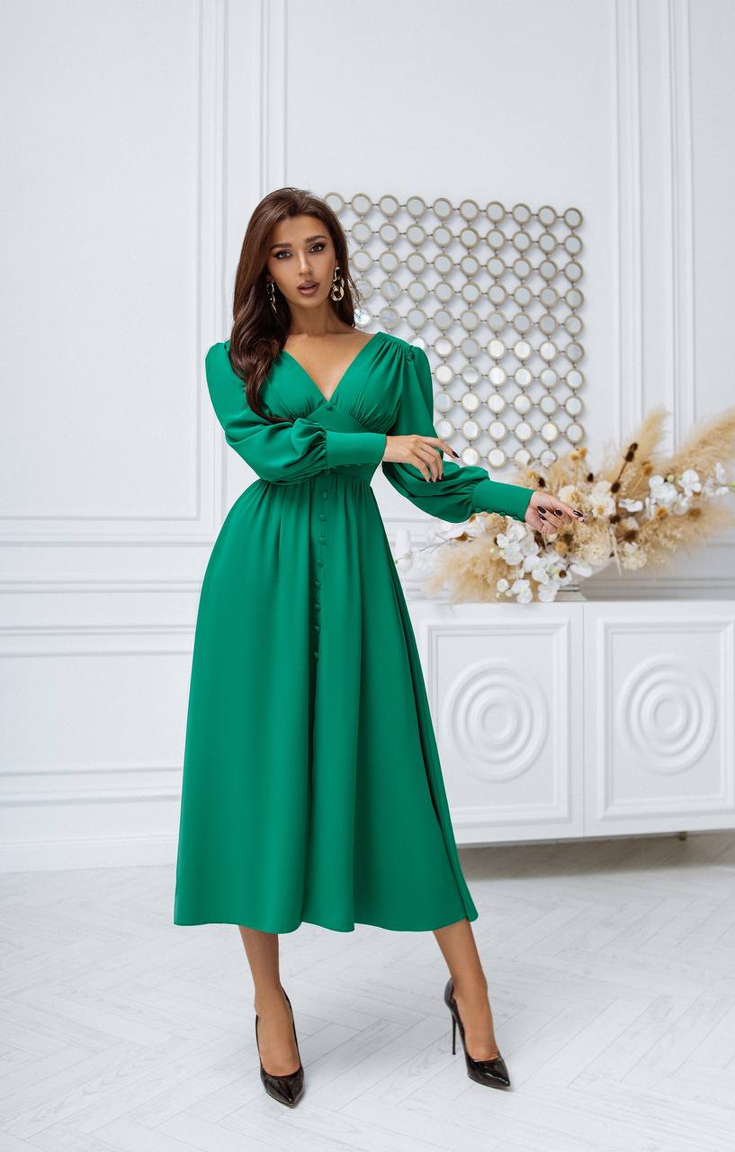 Woman wearing a green dress in an elegant indoor setting