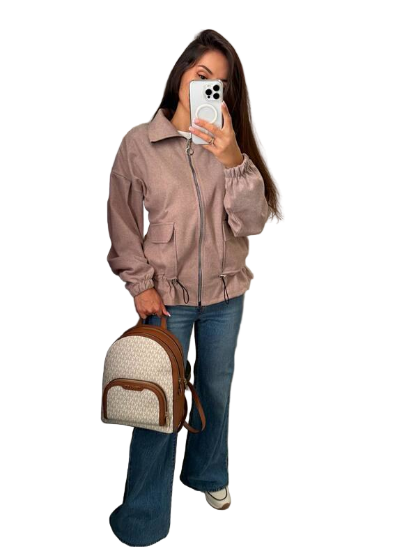 Woman holding a phone and a backpack, wearing a beige jacket and blue jeans on a white background