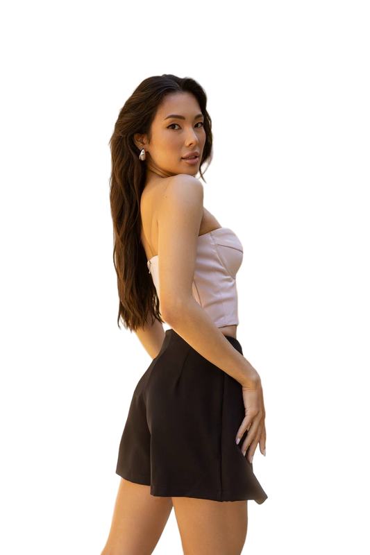 Woman wearing a white top and black shorts on a white background