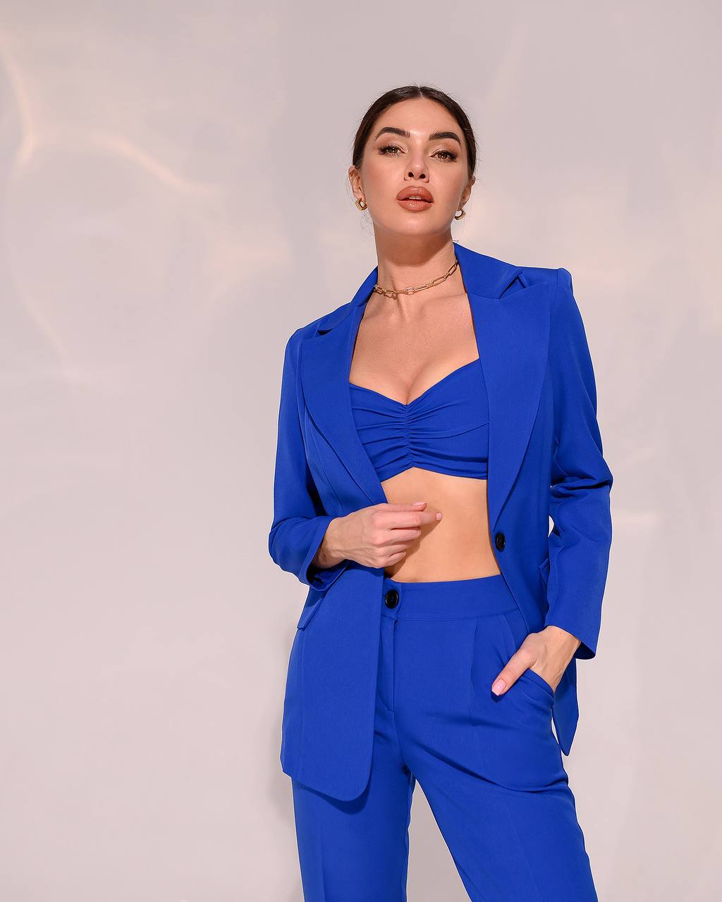 Woman wearing a blue suit against a plain background