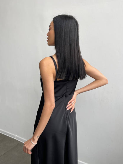 Woman wearing a black dress against a plain background