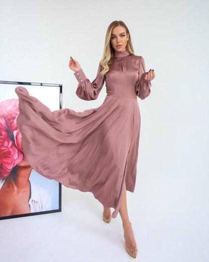 Woman wearing a long, flowing pink dress with a blurred background